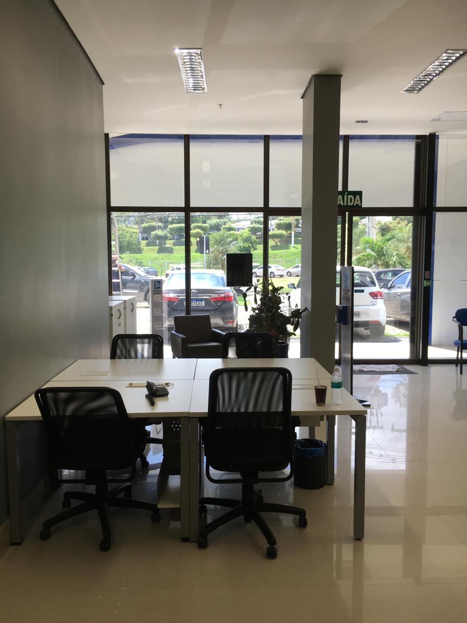 Ambiente de escritório e atendimento com mesas de trabalho e iluminação natural